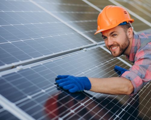 Male worker cleaning solar panels